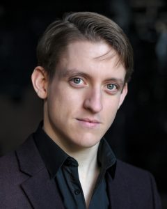 A photo of Matthew Duckett.He has brown hair, blue eyes and a strong jawline