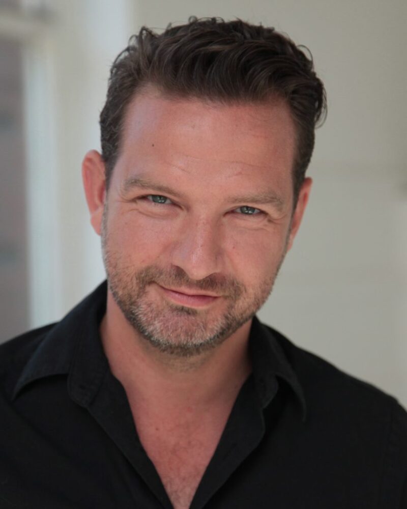 A photo of Richard Conlon. He has short dark brown hair, blue eyes and a greying beard.