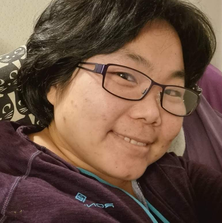 Headshot of Yoonett: Korean lady in her late 40s, wearing a purple fleece and smiling warmly.